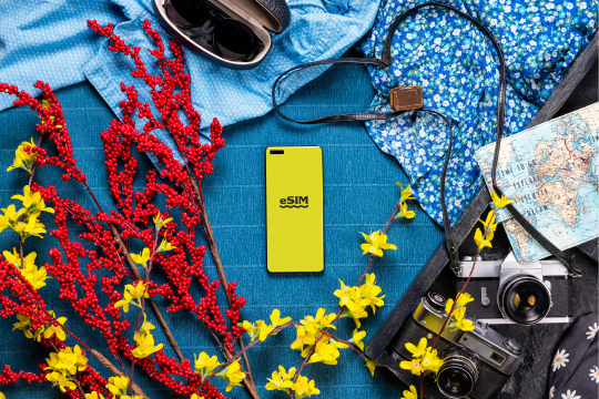 Travel essentials including an iphone displaying Orange eSIM with 30GB data and 120 mins voice calls, symbolizing seamless connectivity across Europe.
